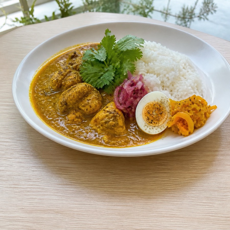 スパイスチキンカレー。白い皿に盛られたカレーとライス。